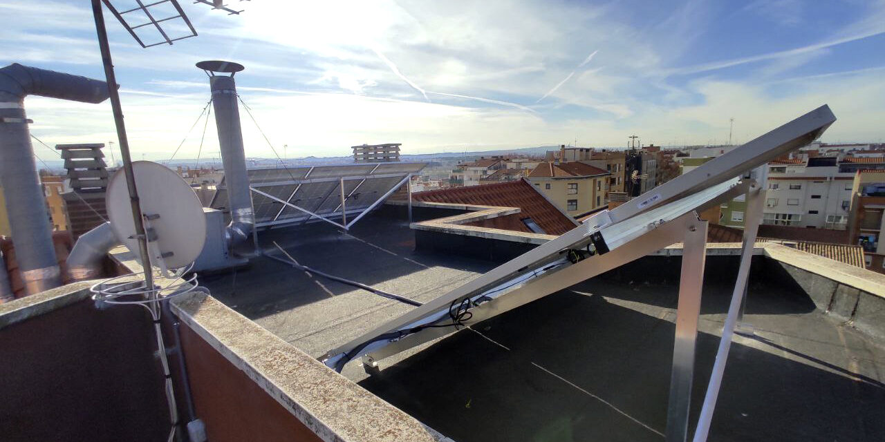 vista posterior de la instalación de 5 paneles en la cubierta plana del edificio de vecinos